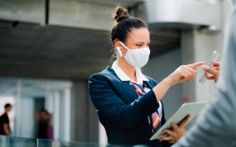 Azafata con mascarilla en aeropuerto