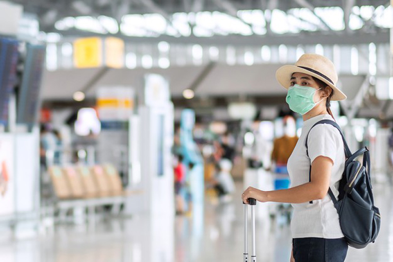 Viajera en aeropuerto con mascarilla