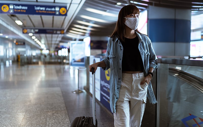 Viajera en aeropuerto con mascarilla